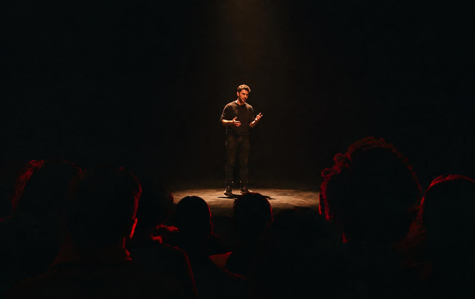 Orador em palco sob um foco de luz